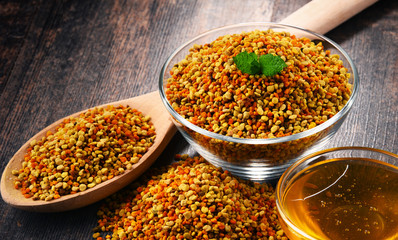 Bowls with bee pollen and honey on kitchen table