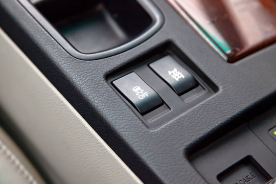 The buttons of the course control system are black and with white signs close-up in the interior of the car on the control console are gray.