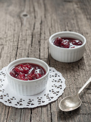 Homemade strawberry sweet tasty jam with whole berries on wooden background