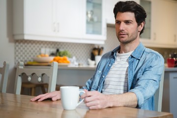 Man having coffee in kitchen at home