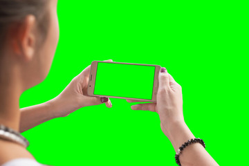 Girl watching a video or play game on a mobile phone. Chroma key isolated.
