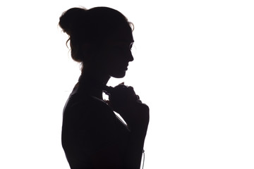 Silhouette of a girl with with headphones around neck, a young woman listening to music on a white...