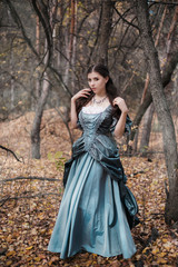 Young woman in historical dress of the nineteenth century in a gloomy forest