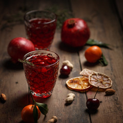 Pomegranate juice with pomegranates and dried fruits on a wooden table. Country style.