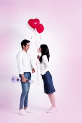 The lady holding balloon in hand,the handsome mand holding ukulele in hand,face to face with sweet emotion,love couple,romantic emotion