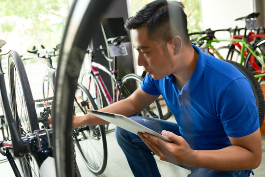 Bicycles Shop Owner With Digital Tablet Checking Every Item In Store