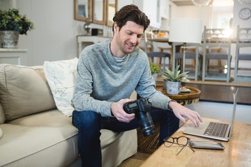 Man using digital camera in living room