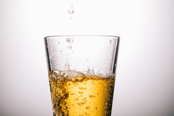 close up of glass of tea and splashes on white background