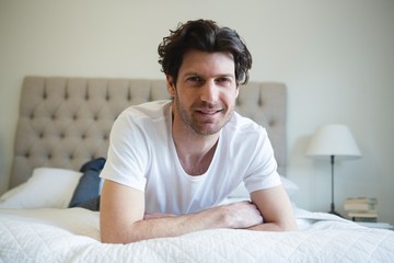 Man relaxing on bed in bedroom at home