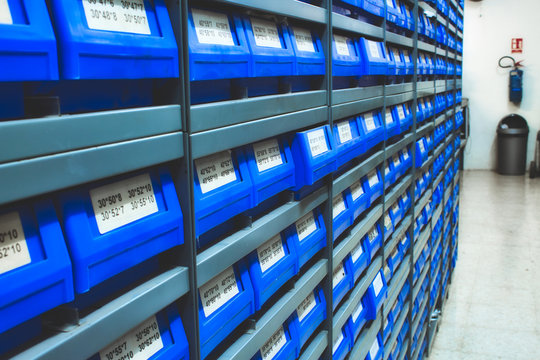 Blue plastic draws of stock / parts in rows of shelves in a warehouse