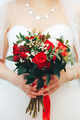 bouquet with red roses in the hands of the bride