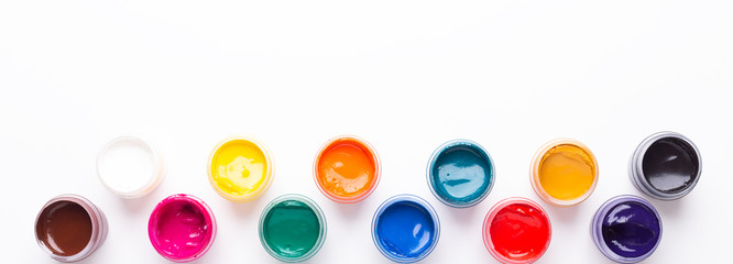 Multicolored gouache on a white background Isolated Paints in containers Top view Copy space Banner Horizontal