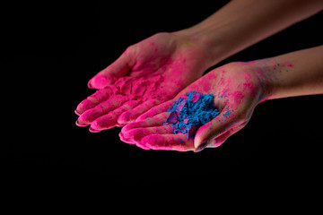 cropped view of adult with hands in pink powder holding blue holi powder isolated on black - Powered by Adobe