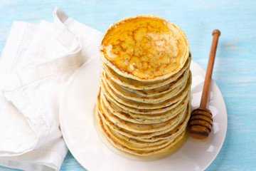 Lemon pancakes with poppy seeds and honey on a blue background. Delicious homemade food