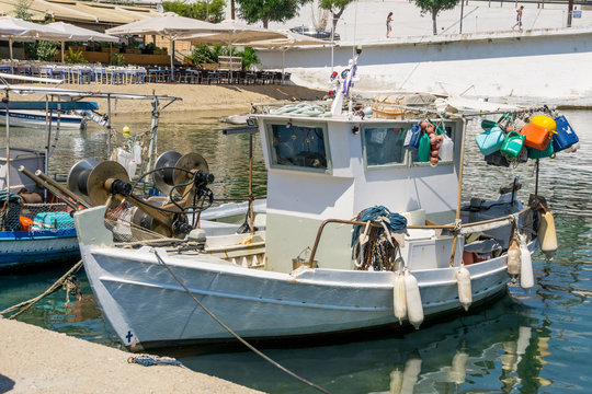 White Overloaded Fishing Boat Anchored Next To The Dock In Town