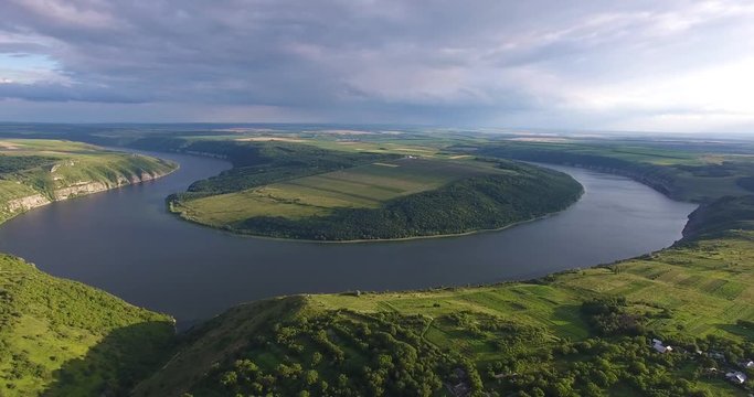 Majestic aerial drone flight through Ukrainian landscape river Dnister. Steep shore with stones. Nature without people. Sunset. Summertime. 4K