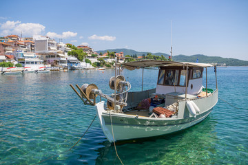 White fishing boat anchored next to the dock in town