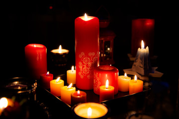 Several burning candles in the dark light