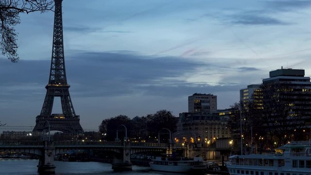 Night to Day timelapse of Eiffel tower in winter with train traffic (RER) on Pont Rouelle in foreground - Paris, France.