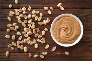Smooth and creamy peanut butter and peanuts on wood table top. Top down view. © Kevin Brine