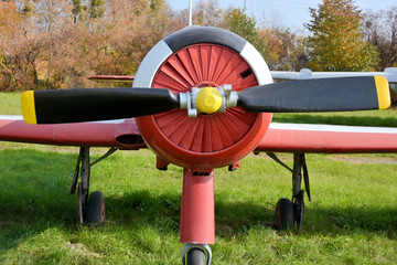 Retro plane with propellers on autumn background. Airplane details with green grass. Aviation...