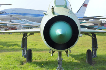  Green jet engine of an airplane with old white plane on background. turbine of an plane with steel blades. Turbo rotor for aviation. Maintenance for air transport industry. 