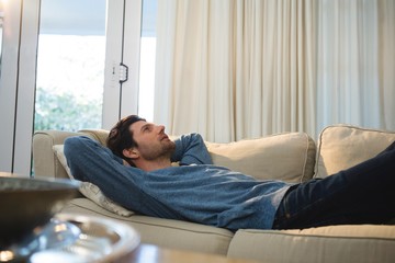 Man relaxing on sofa in living room