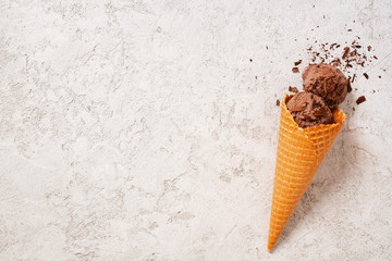 Background with balls of chocolate ice cream in the waffle cone