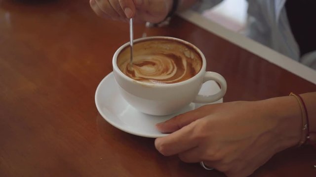 Two woman sharing coffee in cafe, close up shot on coffee cup