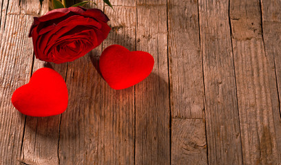 Valentine's day, red hearts and rose on old wooden floor