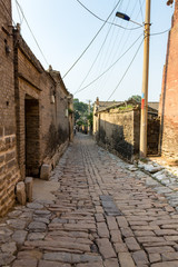 Fototapeta na wymiar One of the streets of the village of Zhangbi Cun, near Pingyao, China, famous for it's underground fortress which is the oldest and longest network of tunnels of all of China