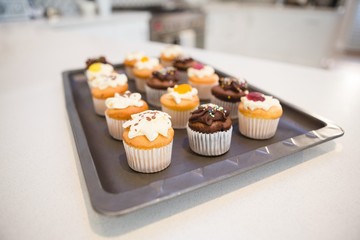 Various cupcakes in tray at home