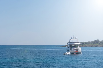 White yacht and small white boat anchored near shore