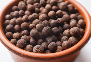 Whole allspice in ceramic bowl