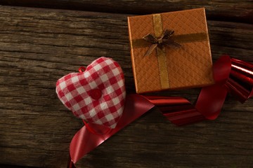 Fototapeta na wymiar Heart shape decorations and gift on wooden plank