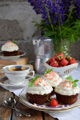 Chocolate cupcake with vanilla cream and strawberries. Vintage style.