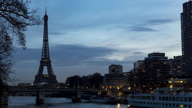 Night to Day timelapse of Eiffel tower in winter with train traffic (RER) on Pont Rouelle in foreground - Paris, France.