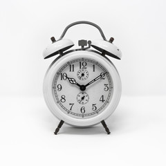 old white analog twin bell alarm clock isolated on a white background. Vintage metal object, ruined by time. Wake up early in the morning to the sound of the bell.