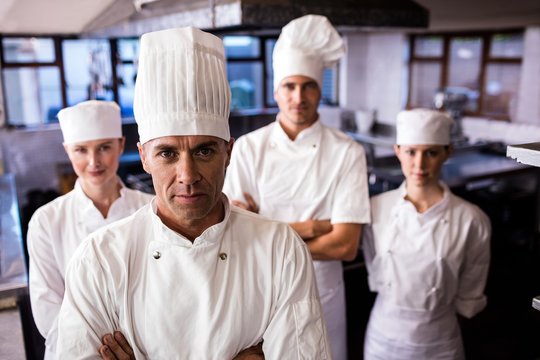 Group Of Chefs Standing In Kitchen