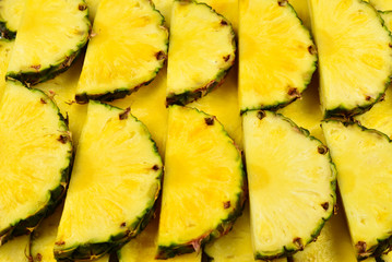 Pineapple juicy yellow slices background. Top view.