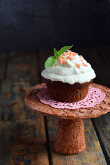 Chocolate cupcake with vanilla cream and mint leaf. Happy Birthday. Dark photo