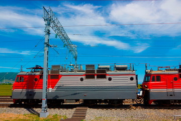 Landscape with electric locomotive on station Trans-Siberian railway in a summer sunny day.