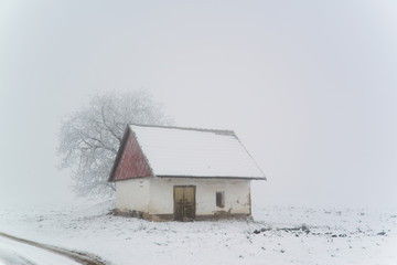 Old house on winter snowy field