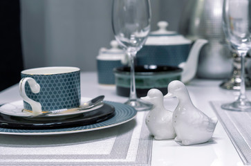 Ceramic salt shakers in the form of ducks in the interior of a modern dining room.