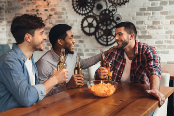 Best friends talking and drinking beer in bar