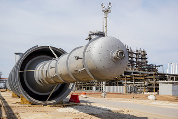 Part of the technological column at the refinery for the production of light oil products on the background of the installation. Manhole for penetration inside.