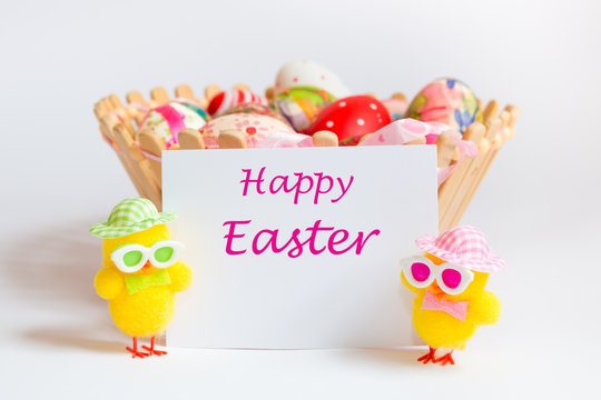 Easter decoration with two funny chicks holding piece of paper with text Happy Easter. Easter holiday concept.
