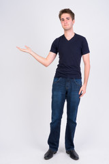 Full body shot of young handsome man showing something © Ranta Images