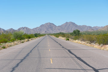 Road through the desert with mountains in the background