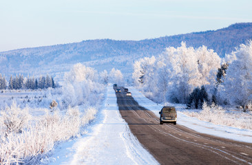 Winter road with beautiful white frosty trees on the sidelines. Journey to the Christmas and New Year holidays